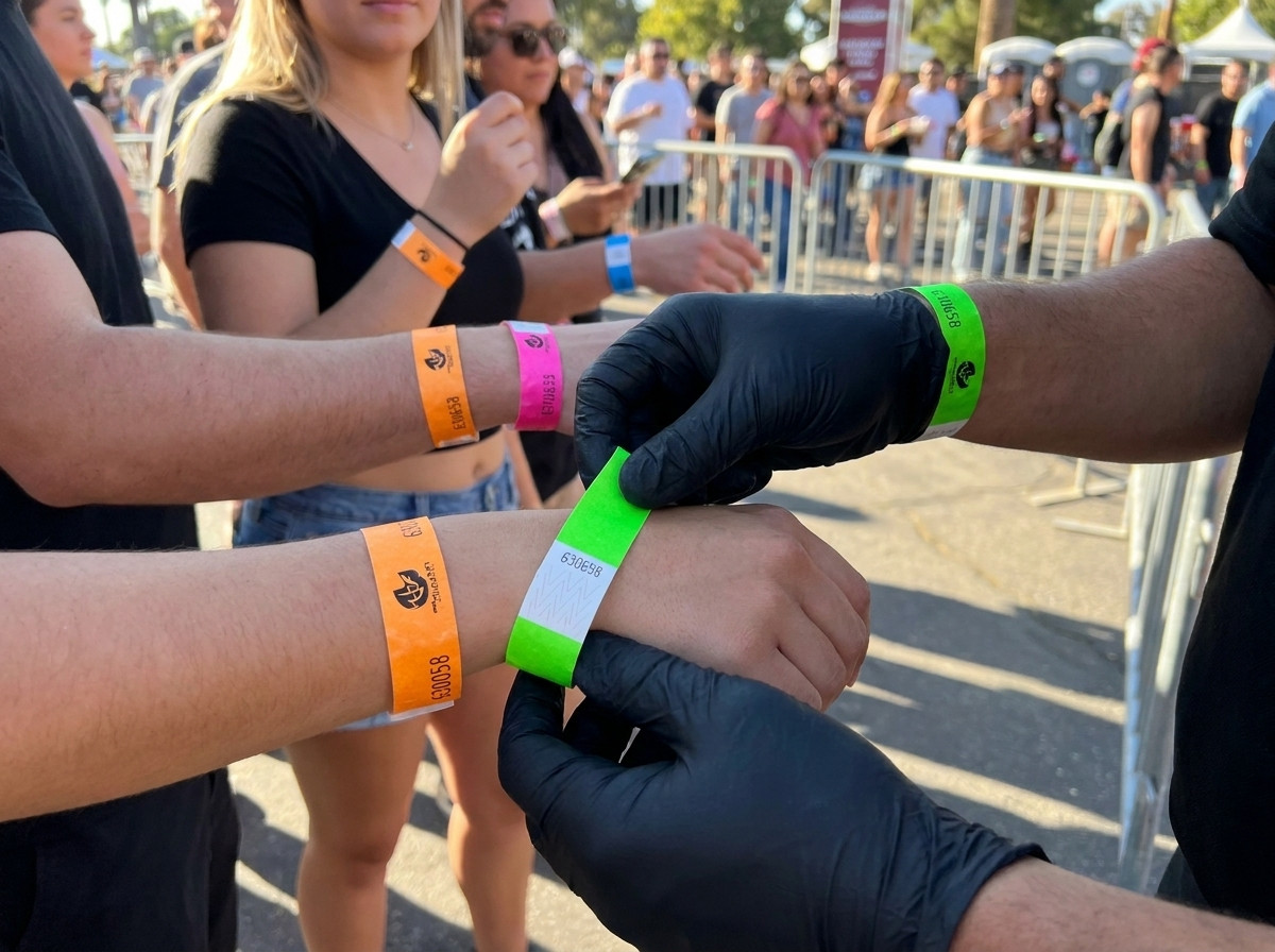 Beveiligingsmedewerker die kleurrijke polsbanden controleert bij de toegangspoort van het evenement