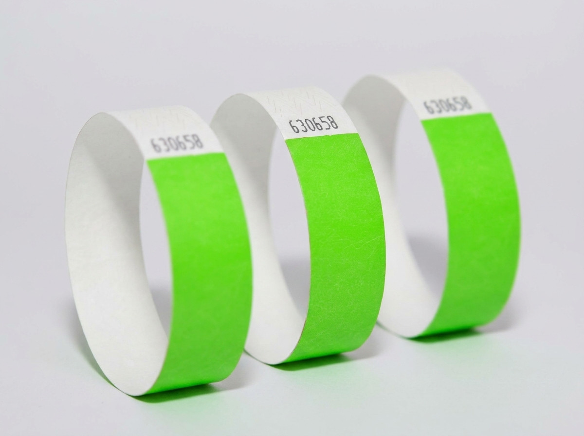 Vergelijking naast elkaar van een gekleurde Tyvek-armband en een elegante witte identificatiearmband op een lichte houten achtergrond
