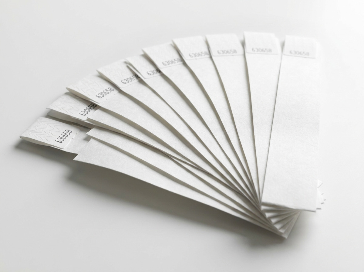 Set witte stijve plastic polsbanden waaiergewijs uitgespreid, klaar om uit te delen
